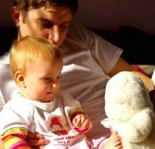 Dad relaxing in a holiday lodge with a baby